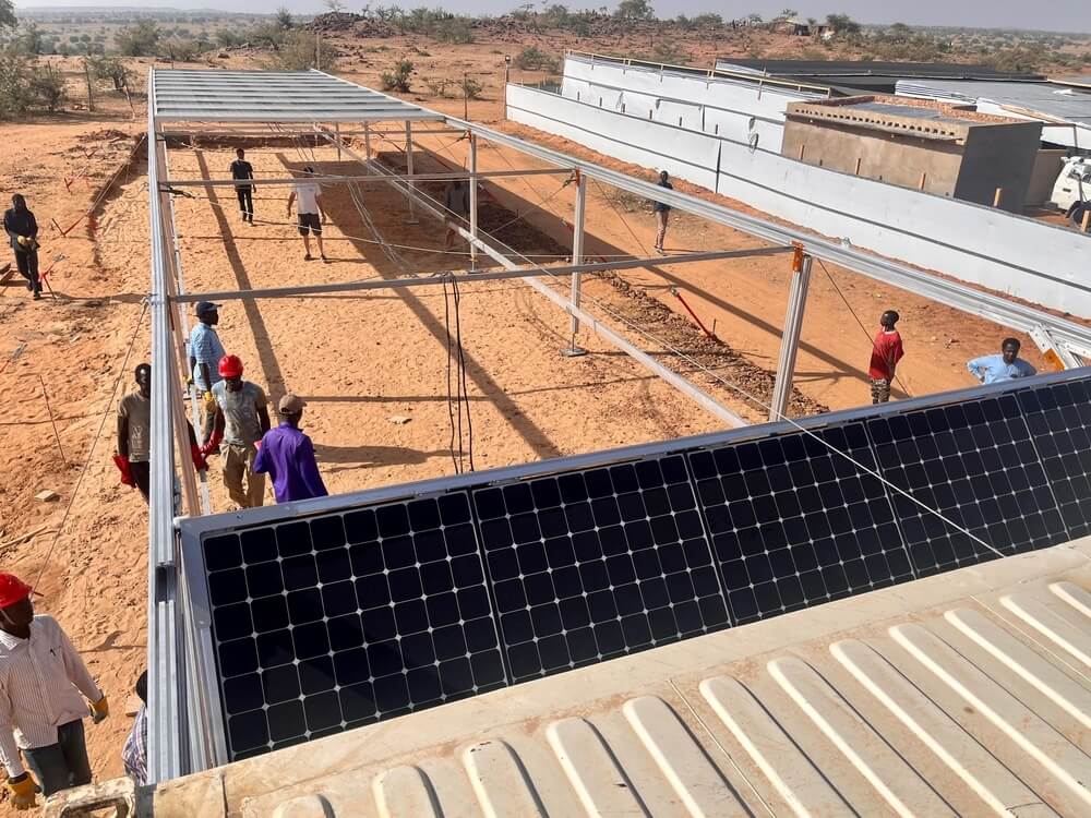 Profissionais da MSF instalam painéis de energia solar no projeto da organização em Ourang, no Chade.